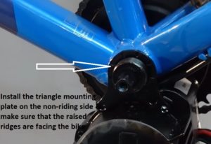 Install the triangle mounting plate on the non-riding side & make sure that the raised ridges are facing the bike