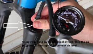 Using your hand screw the shock inflator into the air plug until it pops up to the current air level